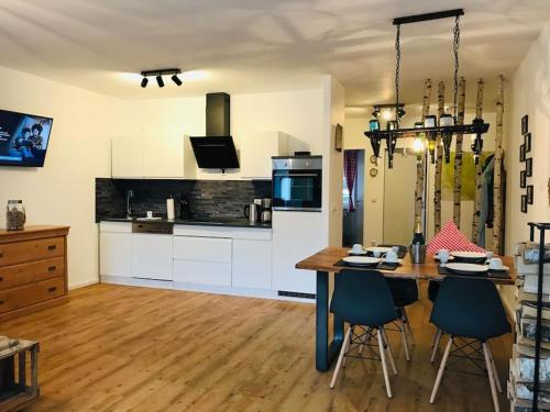 een keuken met een tafel en stoelen in een kamer bij Harzchalet Emma Braunlage in Braunlage