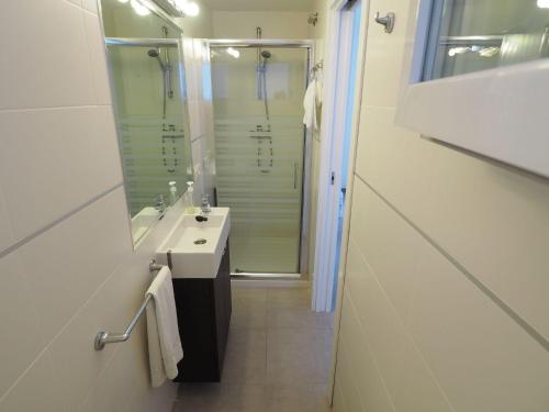 ein weißes Bad mit einem Waschbecken und einer Dusche in der Unterkunft Nerja Paradise Rentals - Villa Verania in Nerja
