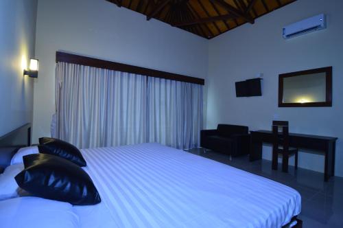 - une chambre avec un lit, une chaise et un bureau dans l'établissement Shu Villa Lombok, à Kuta Lombok