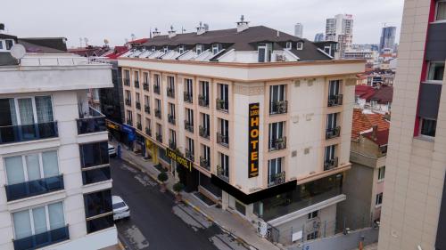 un edificio con una señal amarilla en el costado. en Loss Hotel, en Beylikduzu