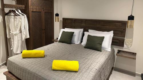 1 dormitorio con 1 cama grande y 2 almohadas amarillas en Amalthea Luxury Suites, en Symi