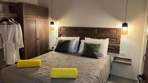 a bedroom with a bed with a yellow pillow on it at Amalthea Luxury Suites in Symi