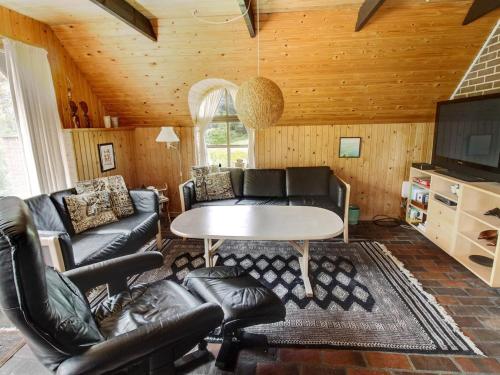 ein Wohnzimmer mit Ledermöbeln und einem Tisch in der Unterkunft Holiday Home Ilva - 300m to the inlet in Western Jutland by Interhome in Ulfborg