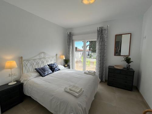 sypialnia z dużym białym łóżkiem i oknem w obiekcie Nerja Paradise Rentals - Villa Suero w mieście Nerja