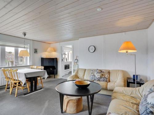 een woonkamer met een bank en een tafel bij Holiday Home Fransiska - from the sea in Western Jutland by Interhome in Ulfborg