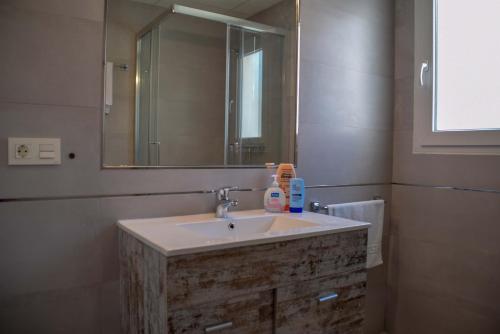 La salle de bains est pourvue d'un lavabo et d'un miroir. dans l'établissement Nerja Paradise Rentals - Villa Valeria, à Nerja