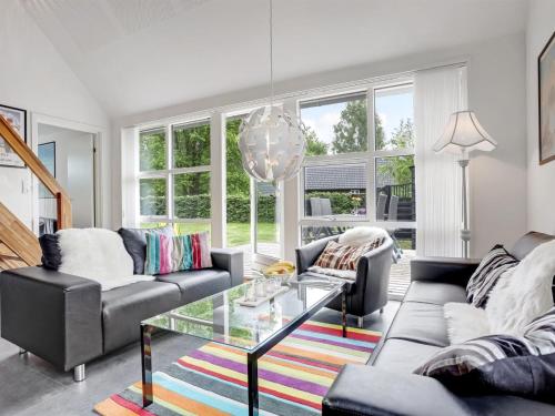 uma sala de estar com dois sofás e uma mesa de vidro em Holiday Home Vilhelm in SE Jutland by Interhome em Give