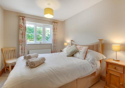 a bedroom with a large bed with towels on it at Oak Lodge in Alderford