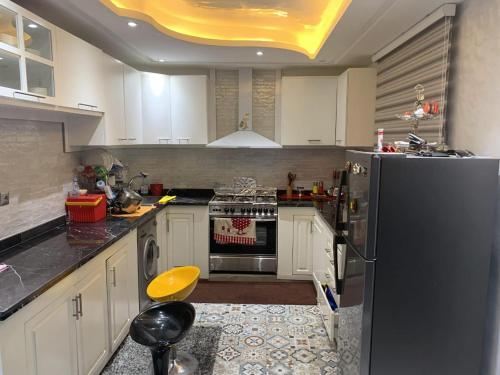 eine Küche mit weißen Schränken und einem schwarzen Kühlschrank in der Unterkunft Villa Ali in Marrakesch