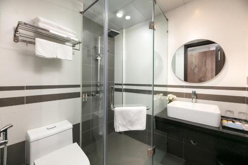 uma casa de banho com um lavatório, um WC e um espelho. em Hanoi Saga Hotel em Hanói