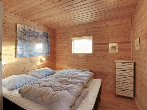 a bedroom with a large bed in a wooden wall at Holiday Home Terese - 45km from the sea in Western Jutland by Interhome in Grindsted
