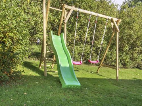 a green slide on a playground in the grass at Holiday Home Terese - 45km from the sea in Western Jutland by Interhome in Grindsted