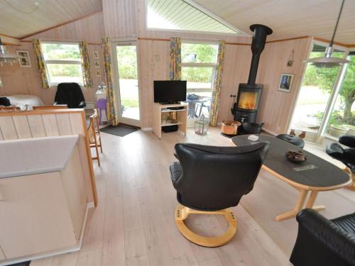 een woonkamer met een stoel, een tafel en een fornuis bij Holiday Home Emille - 300m to the inlet in The Liim Fiord by Interhome in Struer