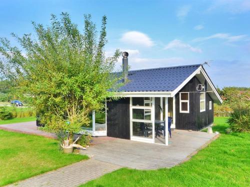 een klein zwart huis met een grote patio bij Holiday Home Emille - 300m to the inlet in The Liim Fiord by Interhome in Struer