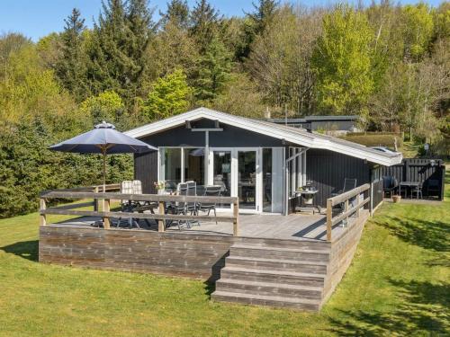 a house with a deck with a table and an umbrella at Holiday Home Matilde - 400m to the inlet by Interhome in Struer