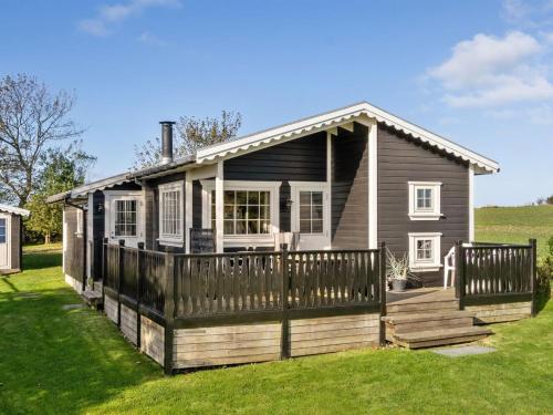 a small house with a porch and a fence at Holiday Home Lenita - 30m to the inlet in The Liim Fiord by Interhome in Thisted