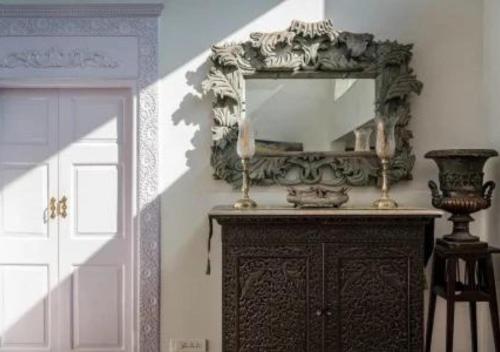 a mirror on top of a dresser in a room at SaffronStays Brunton House, Alibaug - luxury pool villa near Awas Beach in Alibaug