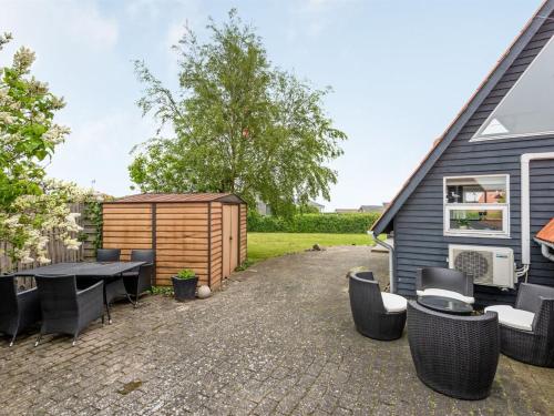 um quintal com uma mesa e cadeiras e um barracão em Holiday Home Leve - 200m from the sea in SE Jutland by Interhome em Sønderby