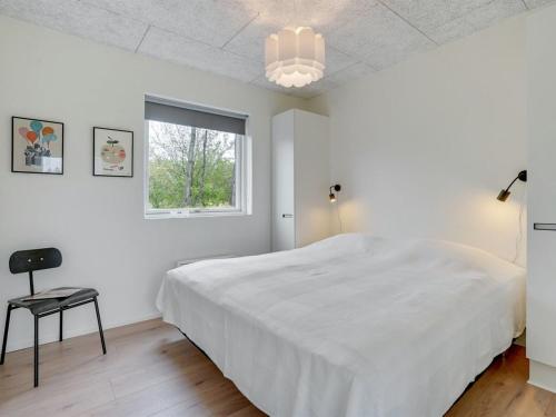 a white bedroom with a large bed and a window at Holiday Home Elso - 600m to the inlet by Interhome in Struer