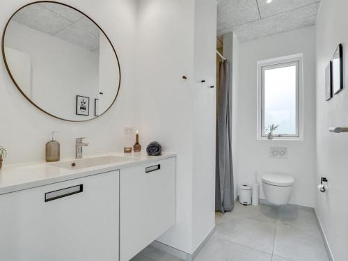 a white bathroom with a sink and a mirror at Holiday Home Elso - 600m to the inlet by Interhome in Struer