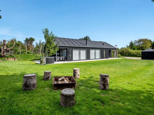 a house in a field with stumps in the grass at Holiday Home Elso - 600m to the inlet by Interhome in Struer