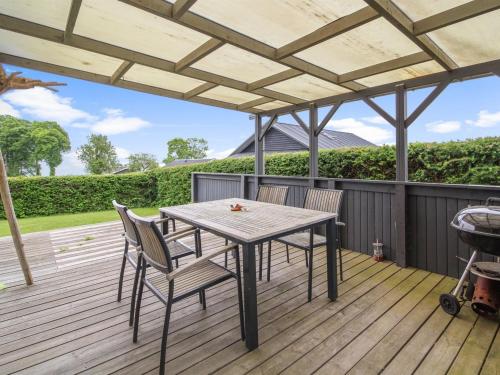 a patio with a table and chairs on a deck at Holiday Home Giselle - 150m from the sea in SE Jutland by Interhome in Sønderby