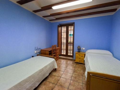 1 dormitorio con 2 camas, escritorio y ventana en CAN CALCETER, en El Castell