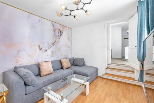 ein Wohnzimmer mit einem grauen Sofa und einer Wand in der Unterkunft Exquisite one-bedroom apartment on Av du Casino in Montreux