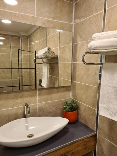 bagno con lavandino, specchio e asciugamani di Ekin Otel Göcek a Göcek