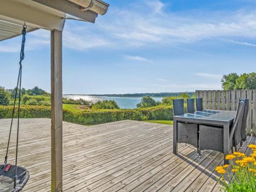 une terrasse en bois avec une table et des chaises. dans l'établissement Holiday Home Peetu - 200m to the inlet in The Liim Fiord by Interhome, à Doverodde