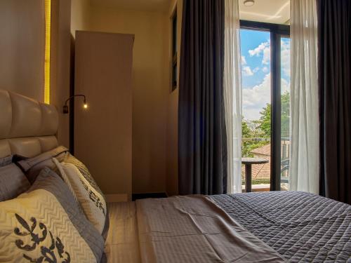Schlafzimmer mit einem Bett und einem Fenster mit Aussicht in der Unterkunft Unique Apartment in Kigali