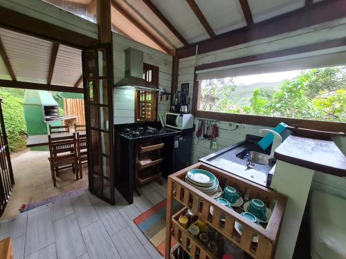 una pequeña cocina con encimera y ventana en Chalé Paúba 80m do Mar, en Pauba