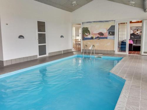 una gran piscina de agua azul en una habitación en Holiday Home Devis - 50m from the sea in NW Jutland by Interhome en Frøstrup