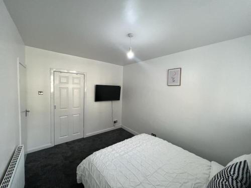 a white bedroom with a bed and a television at Modern Executive 2-Bed Apartment in London in London