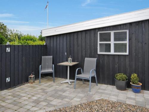 a patio with two chairs and a table in front of a fence at Holiday Home Aliza - 300m to the inlet in The Liim Fiord by Interhome in Roslev