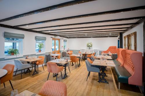 a restaurant with tables and chairs in a room at Tottington Manor Hotel in Henfield