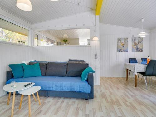 ein Wohnzimmer mit einem blauen Sofa und einem Tisch in der Unterkunft Holiday Home Calli - 400m to the inlet in The Liim Fiord by Interhome in Højslev