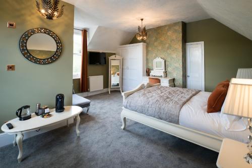 a bedroom with a bed and a table and a mirror at Tottington Manor Hotel in Henfield