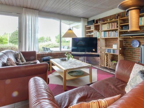 a living room with leather furniture and a tv at Holiday Home Ioar - 200m to the inlet by Interhome in Spottrup