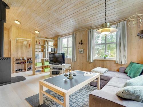 a living room with a couch and a table at Holiday Home Blome - 150m to the inlet by Interhome in Højslev