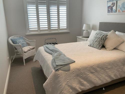 a bedroom with a bed and a chair and a window at Blue House By The Sea Adult Retreat in Kinross