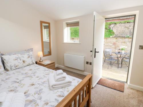 a bedroom with a bed and a balcony with a table at 2 Barn Cottages in Halifax