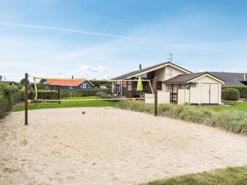 um campo de voleibol de areia em frente a uma casa em Holiday Home Mervi - 300m to the inlet in The Liim Fiord by Interhome em Vinderup