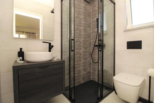 een badkamer met een douche, een toilet en een wastafel bij Ocean View Hydrangea - 2 Bedroom Apartment at São Rafael Beach, Albufeira in Albufeira