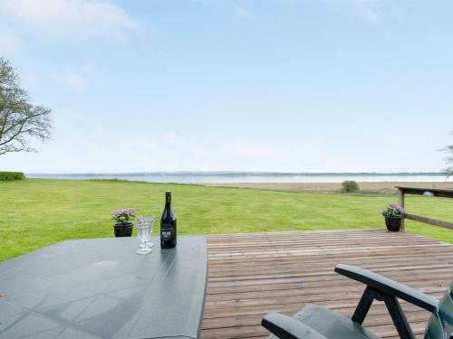 - une bouteille de vin assise sur une table sur une terrasse dans l'établissement Holiday Home Henrieke - 250m to the inlet in The Liim Fiord by Interhome, à Roslev