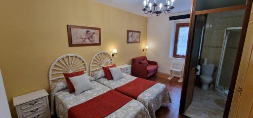 a bedroom with a bed and a chair in it at Río España - Casa amplia con patio y barbacoa en Villaviciosa in Villaviciosa