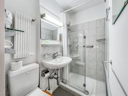 La salle de bains blanche est pourvue d'un lavabo et d'une douche. dans l'établissement Quiet & Comfy apartment on Av du Casino, à Montreux