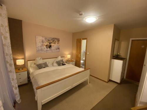 1 dormitorio con 1 cama blanca grande y espejo en Zimmer Nr 4 im Haus Sabine en Braunlage