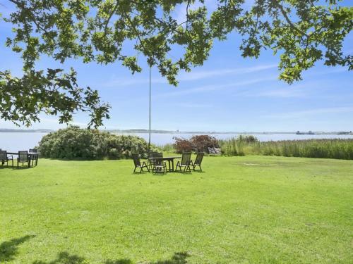 a picnic table and chairs in a field of grass at Holiday Home Rina - 30m to the inlet in The Liim Fiord by Interhome in Fur