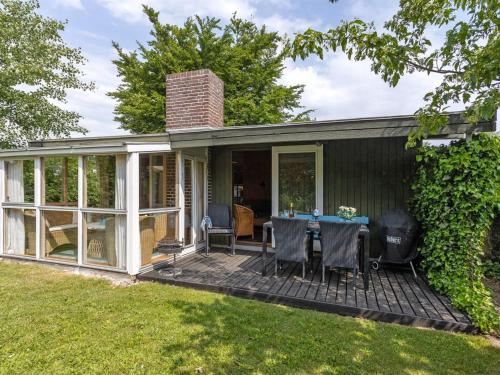 un porche cubierto de una casa con mesa y sillas en Holiday Home Ani - 100m from the sea in SE Jutland by Interhome en Odder